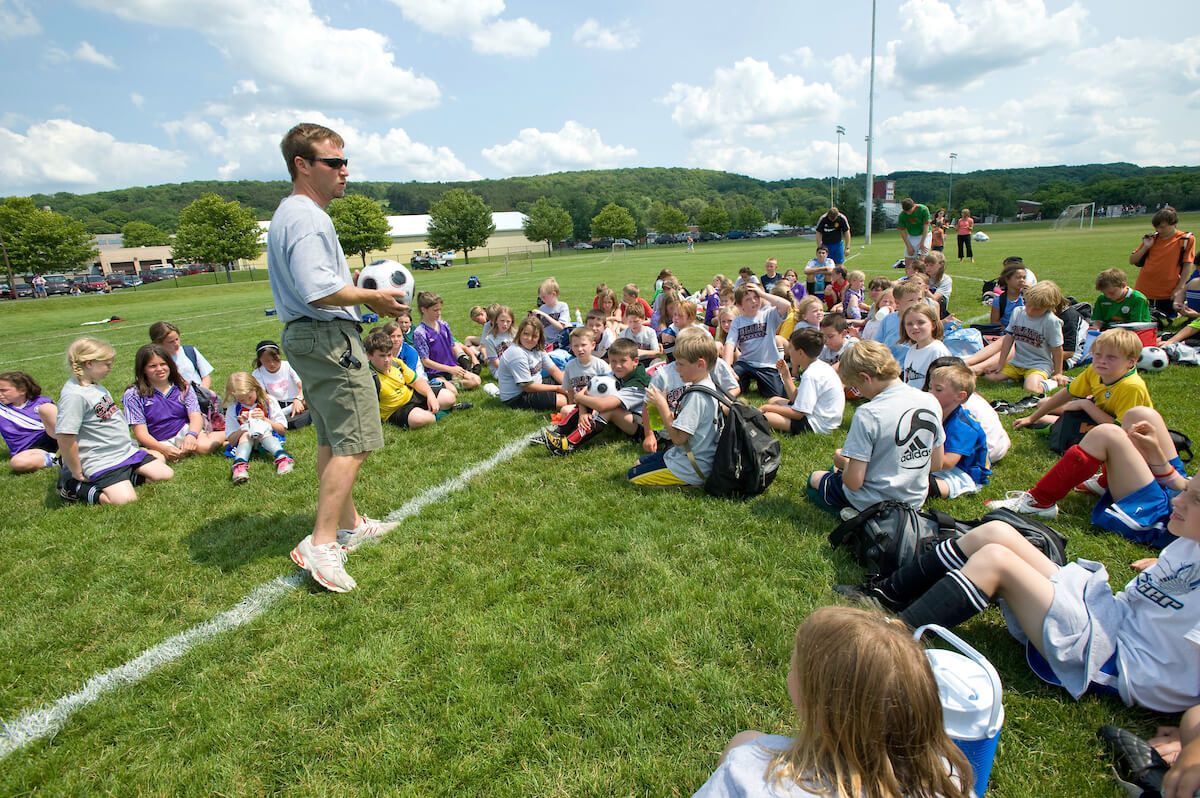PվƵ head soccer coach speaks to participants of a youth soccer camp on the university’s campus.